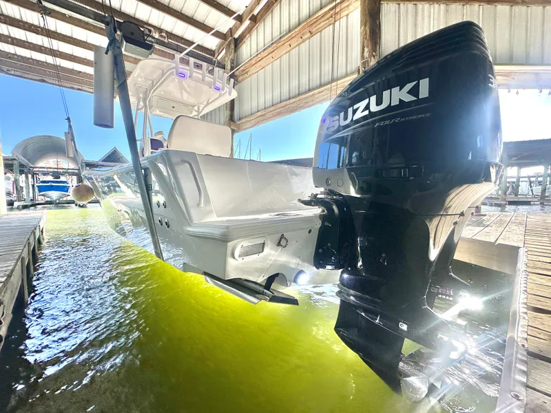 Slide: The Image of 2022 Ocean Runner 29 Center Console with Suzuki outboard in a sunlit dock. - 0