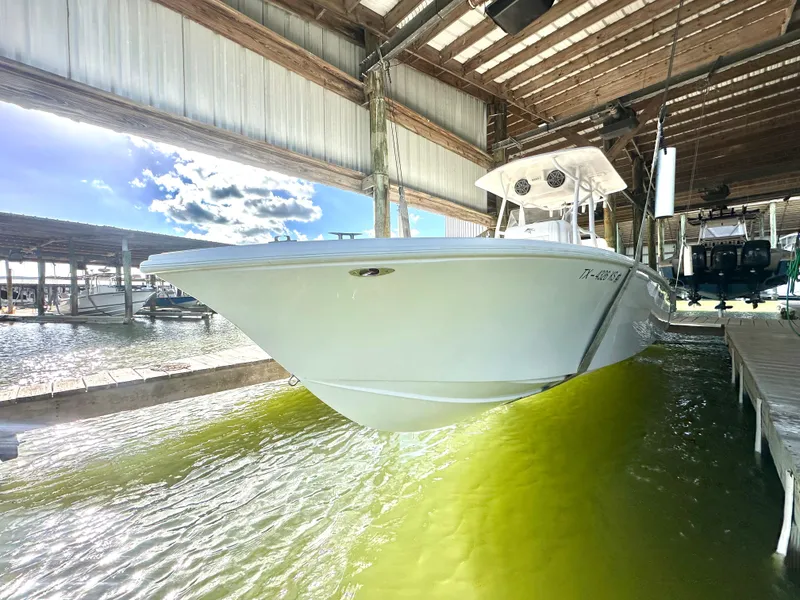 Slide: The Image of 2022 Ocean Runner 29 Center Console boat docked in sunny marina. - 2