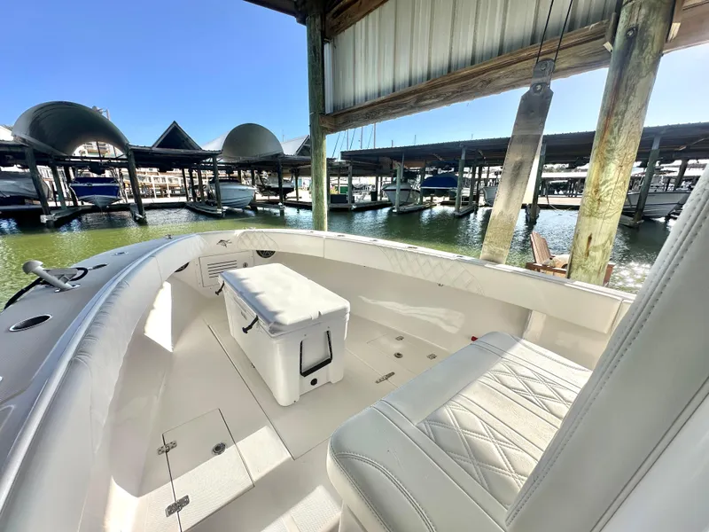 Slide: The Image of 2022 Ocean Runner 29 Center Console boat docked in marina, featuring spacious seating and storage. - 27