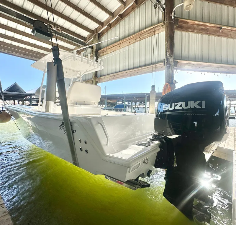 Slide: The Image of 2022 Ocean Runner 29 Center Console boat with Suzuki outboard motor in a marina. - 4