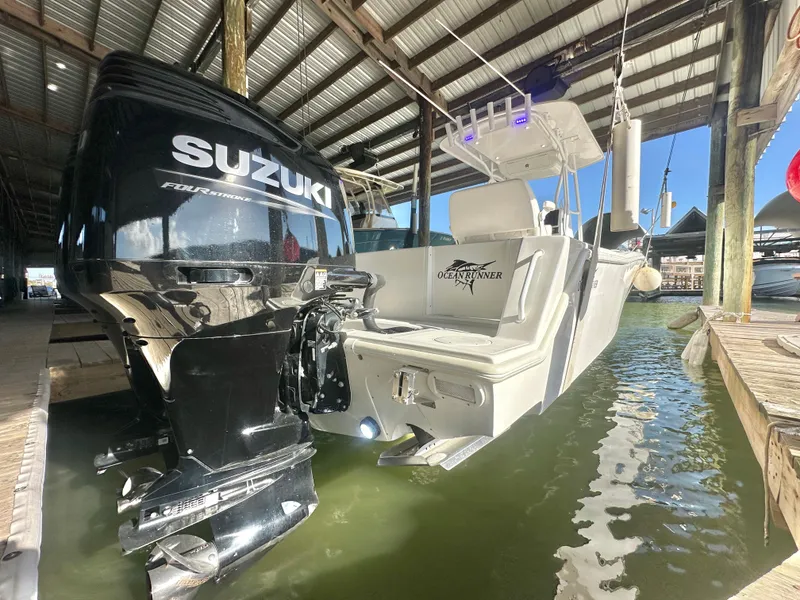 Slide: The Image of 2022 Ocean Runner 29 Center Console with Suzuki outboard in marina. - 9