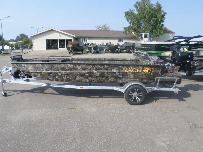 Slide: The Image of 2025 Excel 1854 SWV4 boat on trailer, camo design, parked outdoors. - 1