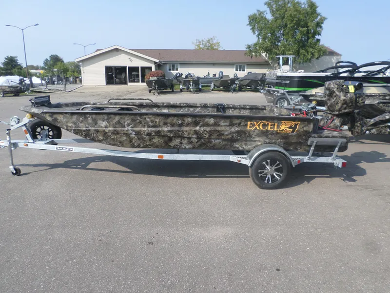 Slide: The Image of 2025 Excel 1860 SWV4 boat on trailer, camo design, parked outdoors. - 1
