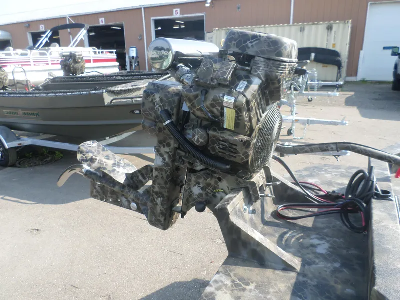 Slide: The Image of Camouflage-patterned engine on Excel 1860 SWV4 boat, 2025 model, in outdoor setting. - 2