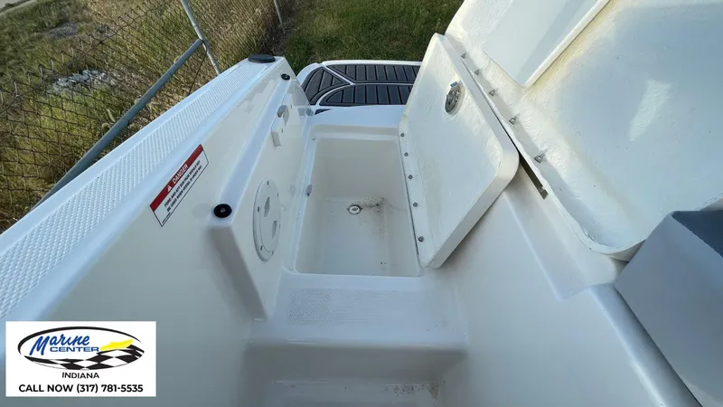 Slide: The Image of 2024 Bayliner VR5 boat storage compartment with open hatch, Marine Center Indiana contact info. - 17