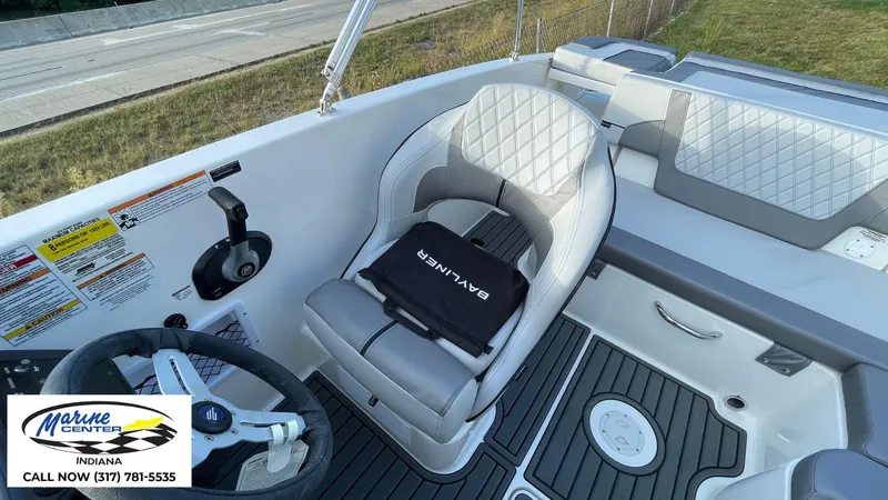 Slide: The Image of 2024 Bayliner VR5 boat interior with steering wheel and seating, Marine Center contact info visible. - 23