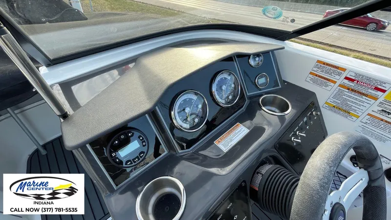 Slide: The Image of 2024 Bayliner VR5 boat dashboard with gauges and controls, Marine Center Indiana contact info. - 7