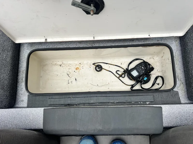 Slide: The Image of Open storage compartment in 2009 Ranger 208 VX boat with electronic device inside. - 24