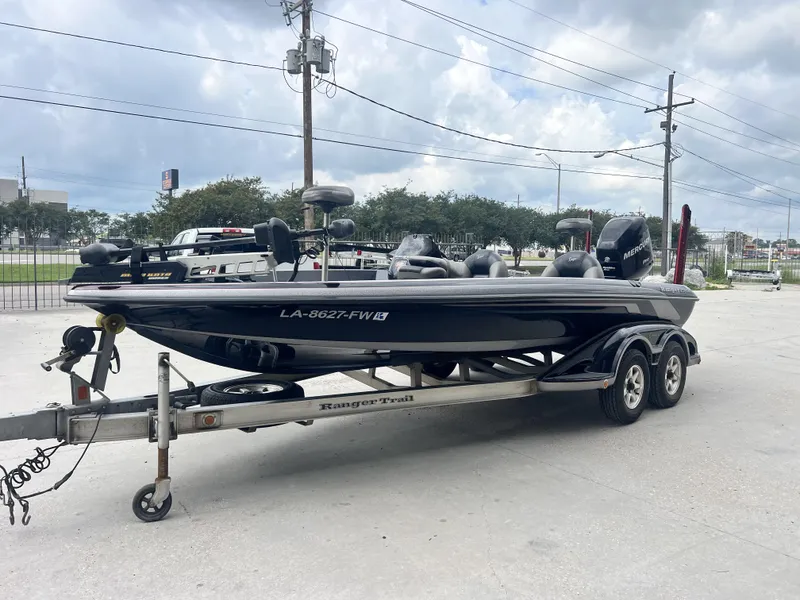 Slide: The Image of 2009 Ranger 208 VX boat on trailer, parked outdoors under cloudy sky. - 3