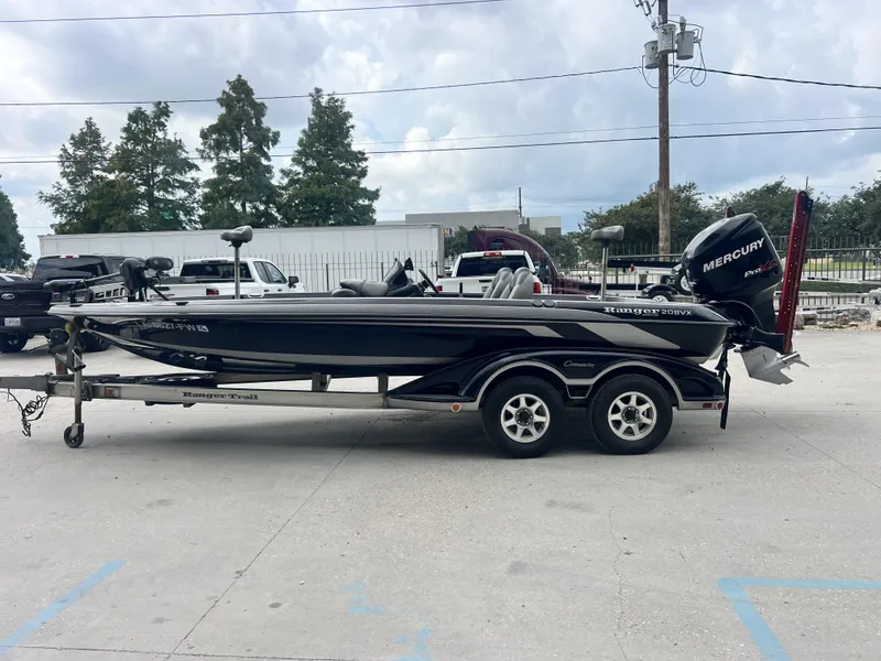 Slide: The Image of 2009 Ranger 208 VX boat on trailer with Mercury engine, parked outdoors. - 4