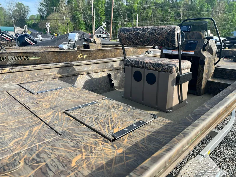 Slide: The Image of 2025 G3 Gator Tough 18 CCJ boat with camo seats and console, parked outdoors. - 10