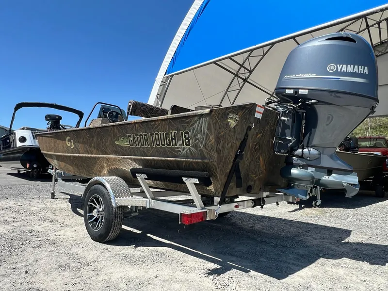 Slide: The Image of 2025 G3 Gator Tough 18 CCJ boat with Yamaha engine on trailer, under blue sky. - 18