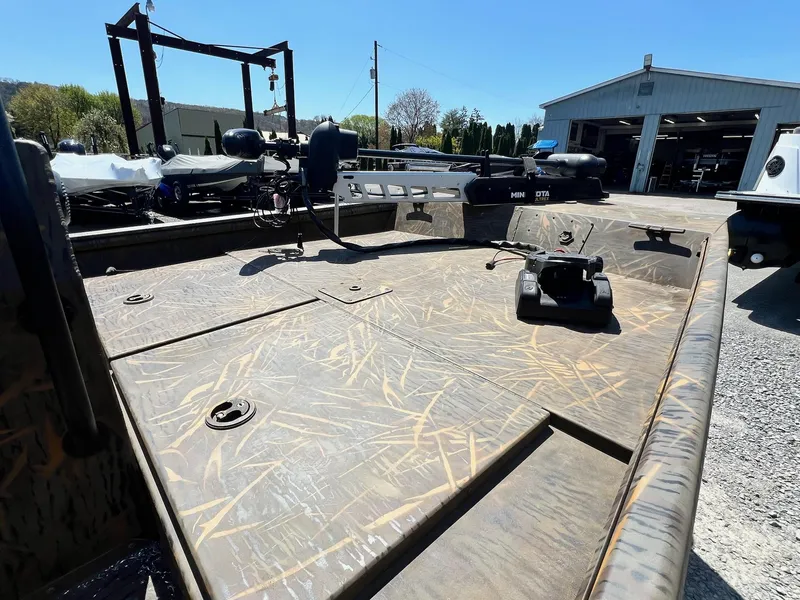 Slide: The Image of 2025 G3 Gator Tough 18 CCJ boat with camo deck, parked outdoors. - 23