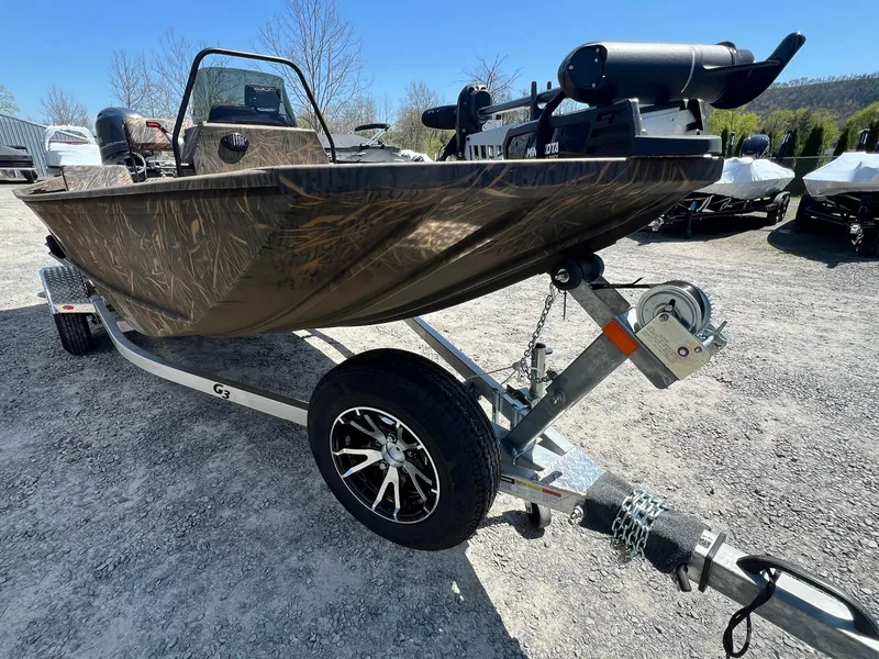 Slide: The Image of 2025 G3 Gator Tough 18 CCJ boat on trailer, camo design, parked outdoors. - 25