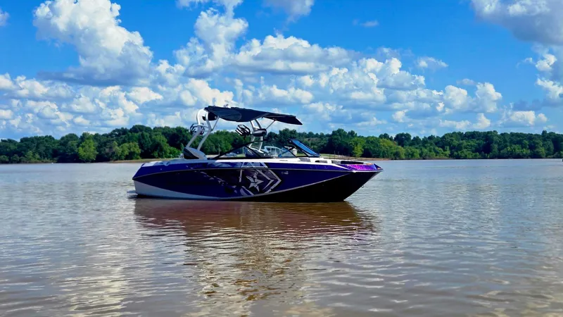 Slide: The Image of 2014 Nautique Super Air Nautique G21 boat on calm lake under blue sky. - 18