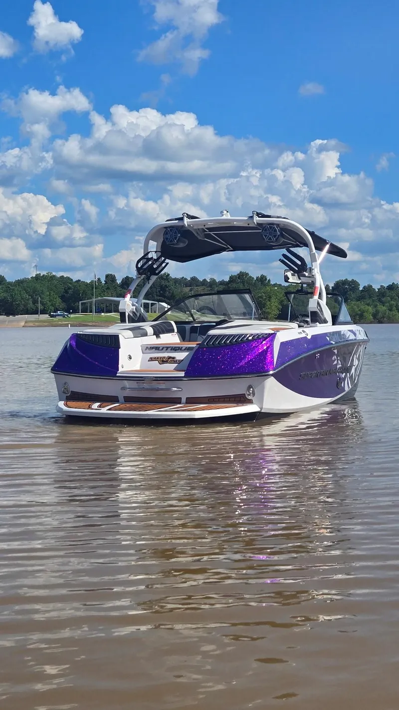 Slide: The Image of 2014 Nautique Super Air Nautique G21 boat on calm water under a blue sky. - 19