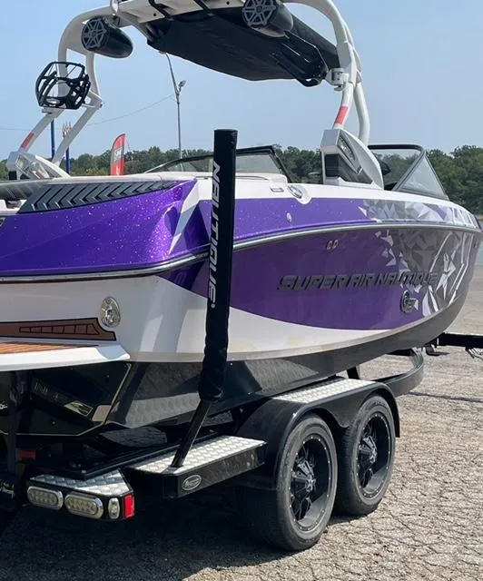 Slide: The Image of 2014 Nautique Super Air Nautique G21 boat with purple and white design on a trailer. - 3