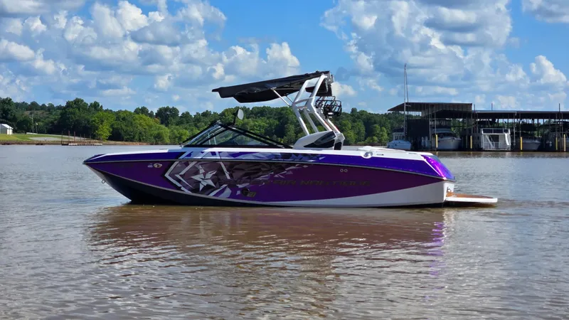 Slide: The Image of 2014 Nautique Super Air Nautique G21 boat on a lake under a cloudy sky. - 5