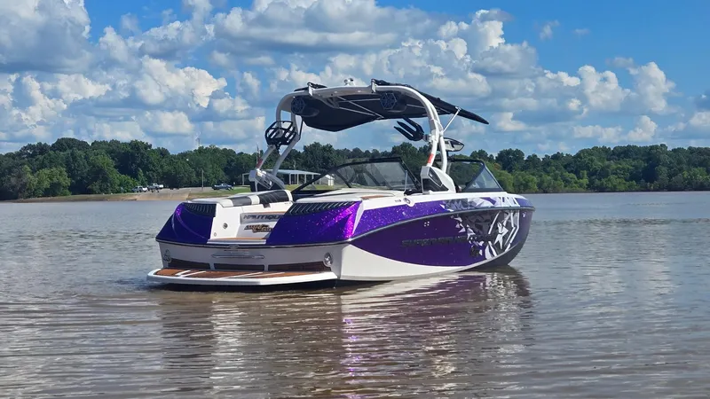 Slide: The Image of 2014 Nautique Super Air Nautique G21 boat on calm lake under blue sky. - 6