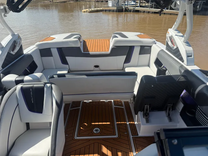 Slide: The Image of 2014 Nautique Super Air Nautique G21 interior with luxurious seating and teak flooring. - 9