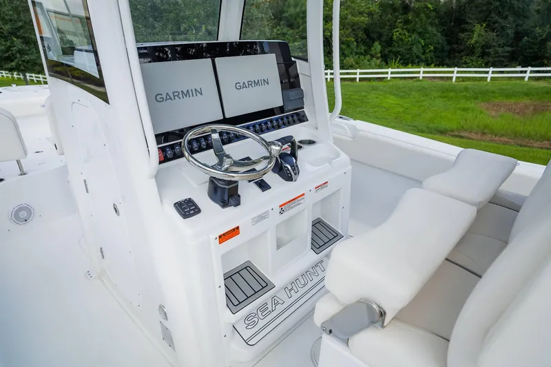 Slide: The Image of 2025 Sea Hunt Gamefish 28 FS boat cockpit with Garmin displays and white seating. - 16