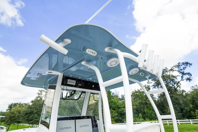 Slide: The Image of 2025 Sea Hunt Gamefish 28 FS boat with T-top and rod holders against a blue sky. - 4