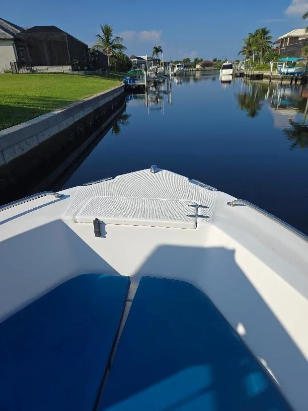 Slide: The Image of 2008 Sea Hunt Triton 220 boat on a calm canal with clear skies. - 11