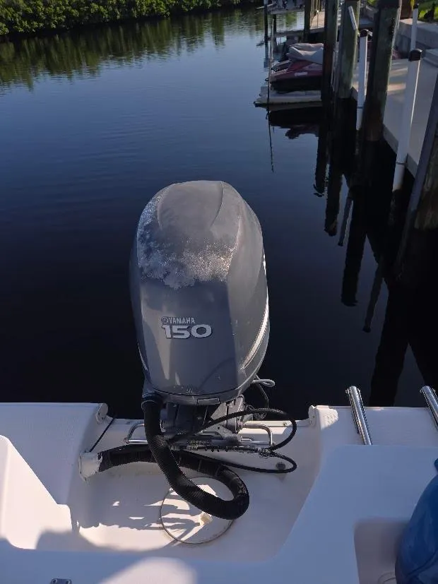 Slide: The Image of 2008 Sea Hunt Triton 220 with Yamaha 150 engine, docked by calm waters. - 17