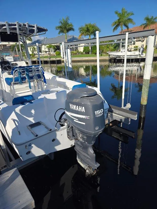 Slide: The Image of 2008 Sea Hunt Triton 220 boat with Yamaha 150 engine docked by palm trees. - 18