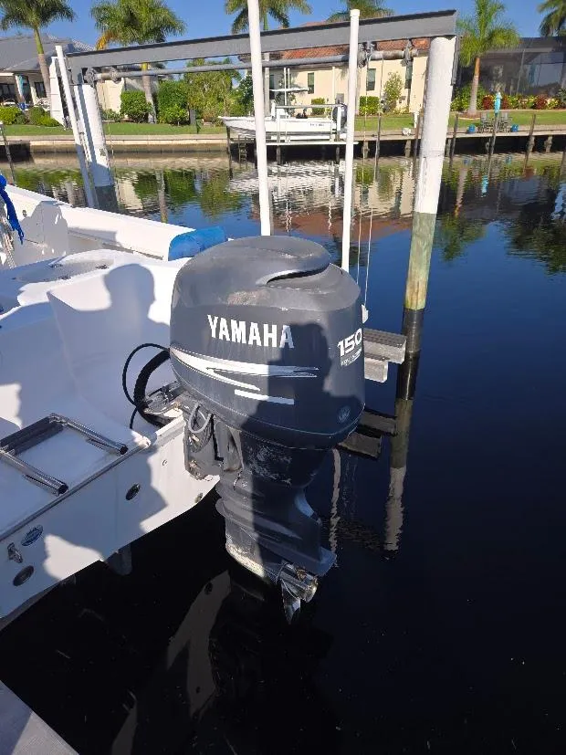 Slide: The Image of 2008 Sea Hunt Triton 220 with Yamaha 150 outboard motor docked by waterfront. - 19