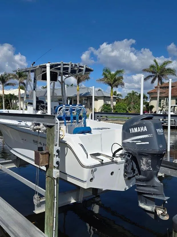 Slide: The Image of 2008 Sea Hunt Triton 220 boat with Yamaha 150 engine docked by palm trees. - 21