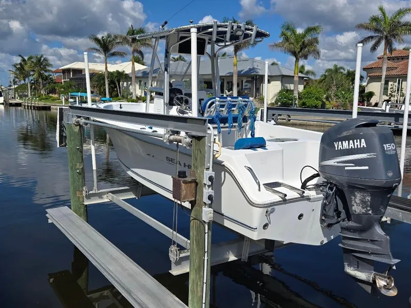 Slide: The Image of 2008 Sea Hunt Triton 220 boat with Yamaha 150 engine on a lift by a canal. - 22