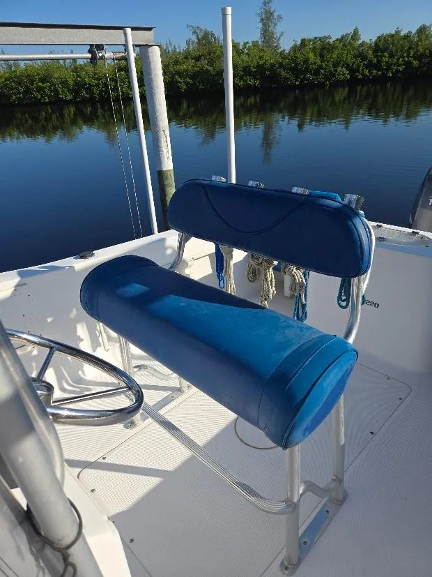 Slide: The Image of 2008 Sea Hunt Triton 220 boat with blue seating by a calm river. - 3