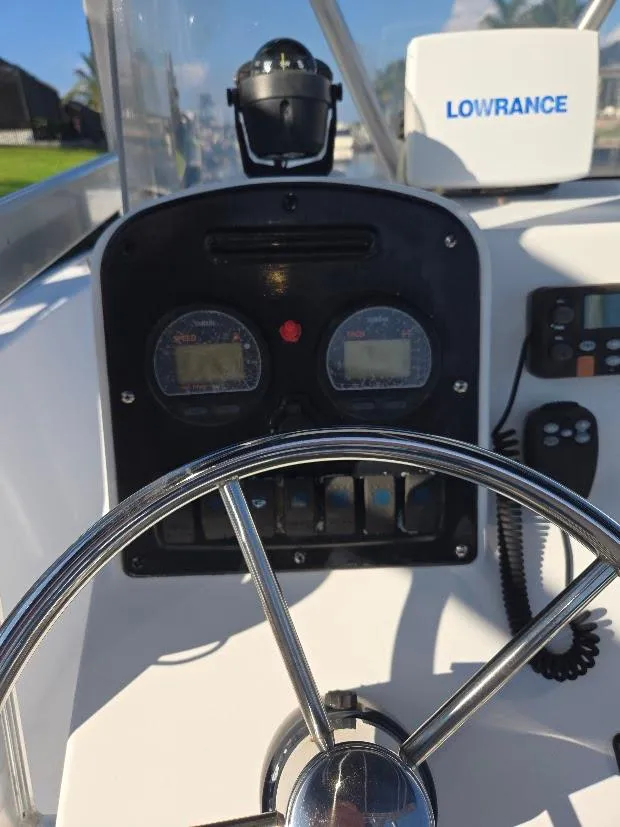 Slide: The Image of 2008 Sea Hunt Triton 220 boat dashboard with steering wheel and navigation instruments. - 4