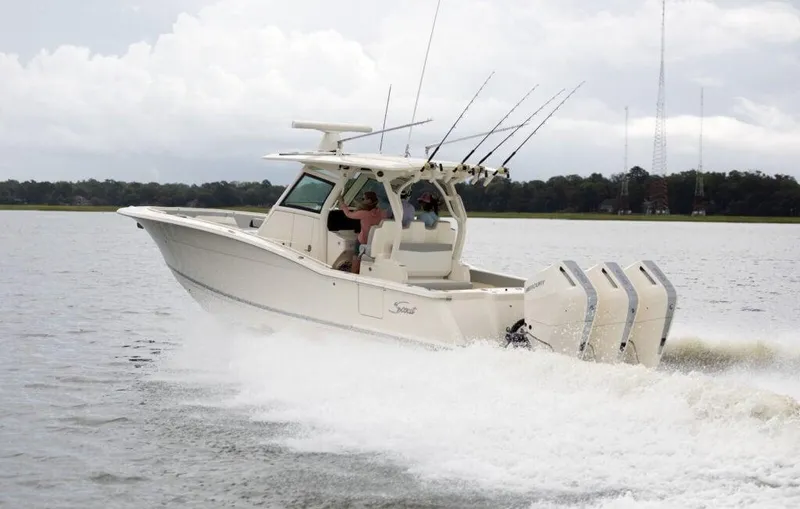 Slide: The Image of 2025 Scout 357 LXF boat cruising on a lake with fishing rods. - 1