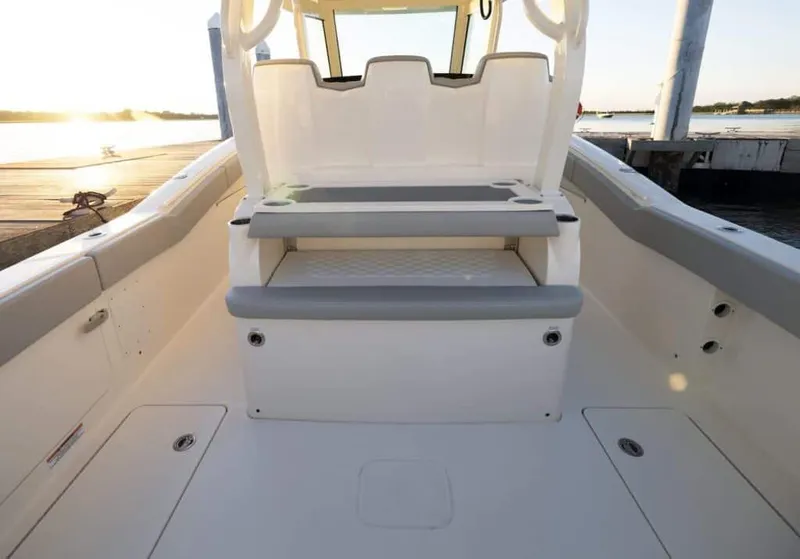 Slide: The Image of 2025 Scout 357 LXF boat interior with seating, docked at sunset. - 17