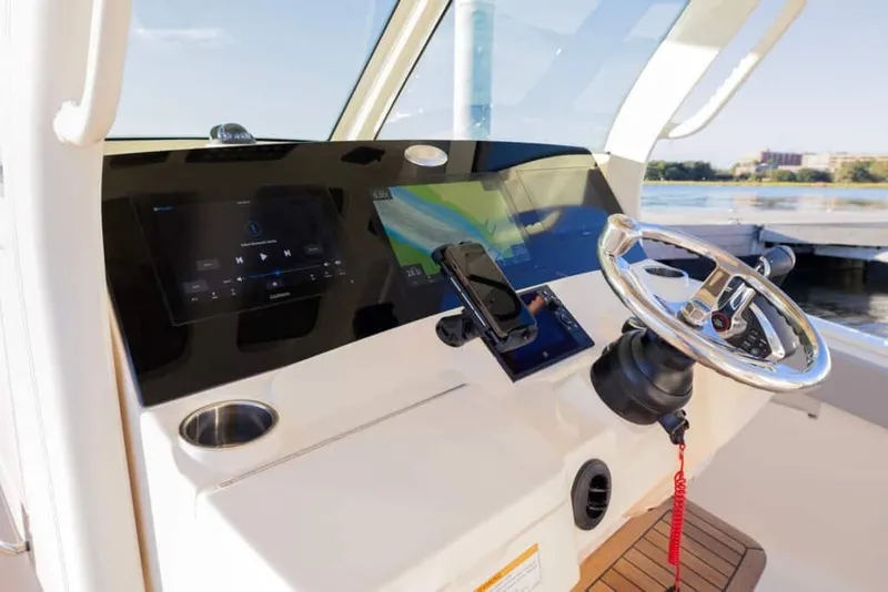 Slide: The Image of 2025 Scout 357 LXF boat dashboard with steering wheel and navigation screens. - 18