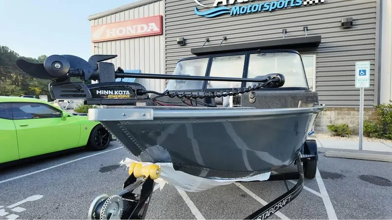 Slide: The Image of 2025 Starcraft Storm 166 DC Pro boat with Minn Kota motor in dealership parking lot. - 3
