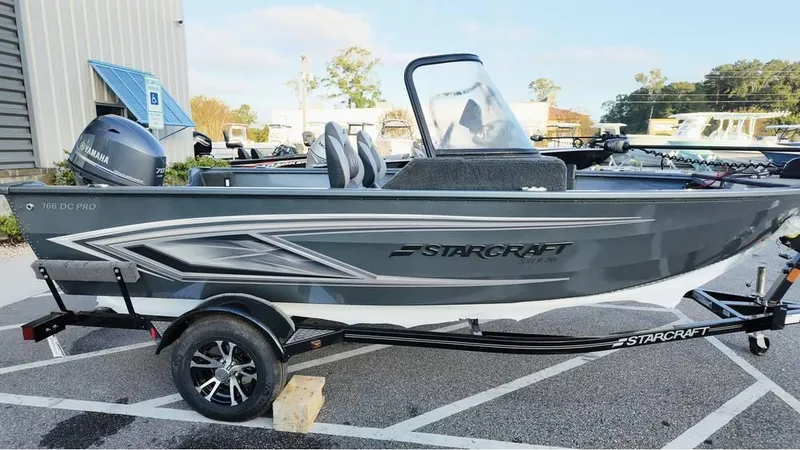 Slide: The Image of 2025 Starcraft Storm 166 DC Pro boat on trailer, gray exterior, parked outdoors. - 4