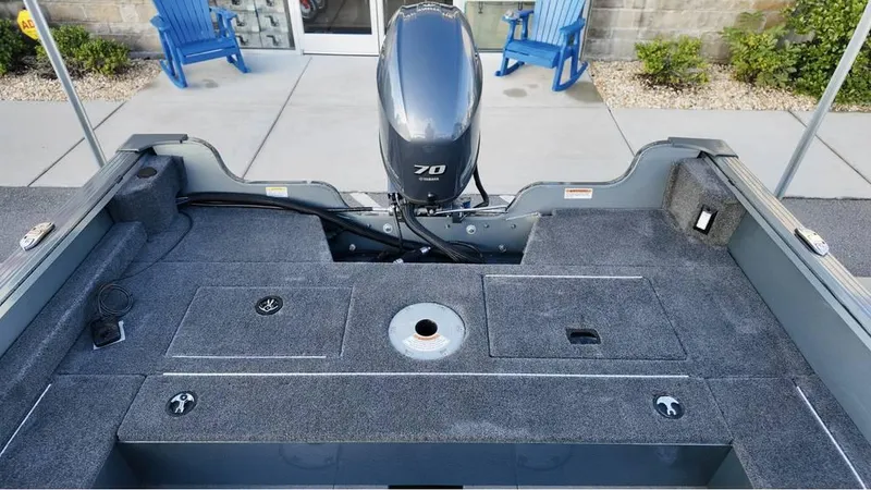 Slide: The Image of 2025 Starcraft Storm 166 DC Pro boat interior with motor, gray carpet, and storage compartments. - 7