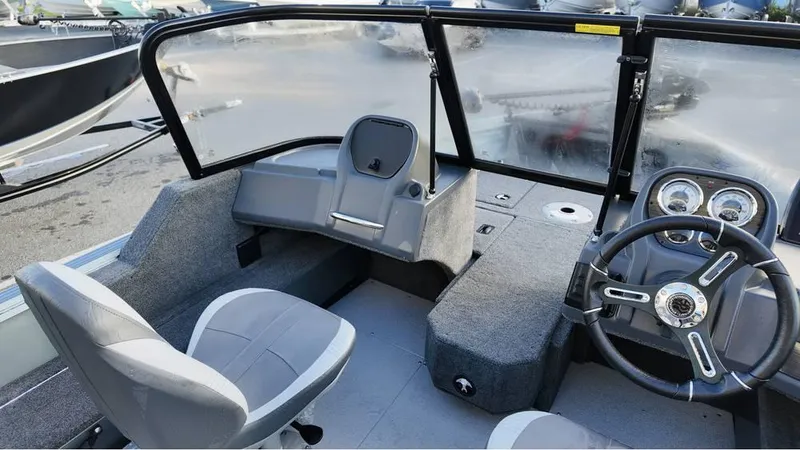 Slide: The Image of 2025 Starcraft Storm 166 DC Pro boat interior with steering wheel and seating. - 8