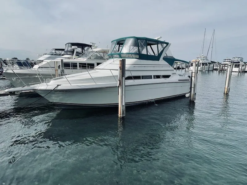 The Image of 1995 Carver 380 Santego yacht docked in a marina, surrounded by water and other boats. - 0
