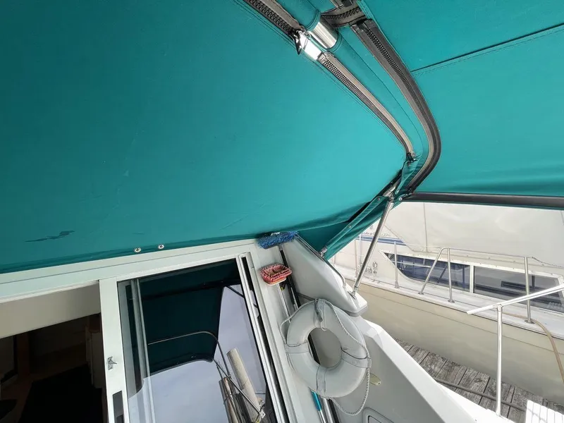 Slide: The Image of 1995 Carver 380 Santego boat with teal canopy and dock view. - 13