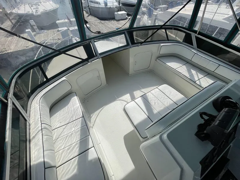 Slide: The Image of 1995 Carver 380 Santego boat interior with white seating and panoramic windows. - 15