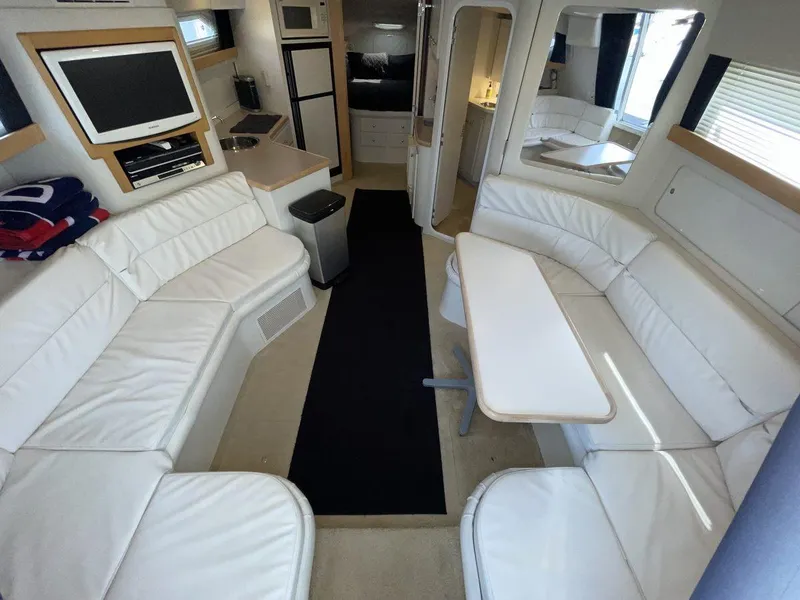 Slide: The Image of 1995 Carver 380 Santego yacht interior with white seating, dining table, and entertainment area. - 30