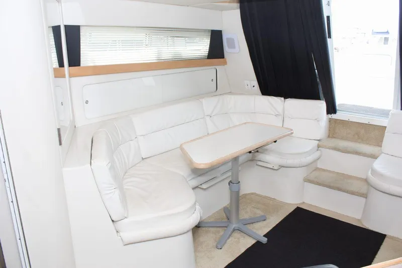 Slide: The Image of Interior of 1995 Carver 380 Santego yacht with white seating and table. - 32