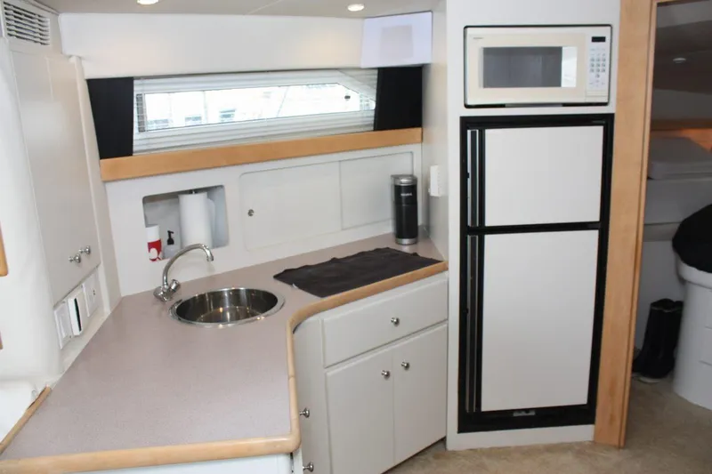 Slide: The Image of 1995 Carver 380 Santego yacht kitchen with sink, microwave, and storage cabinets. - 39