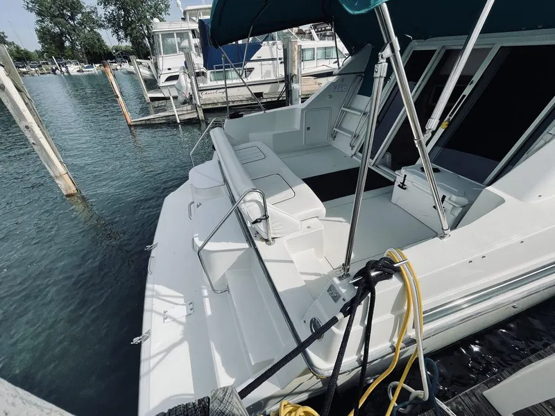 Slide: The Image of 1995 Carver 380 Santego yacht docked at marina, featuring spacious deck and seating area. - 4