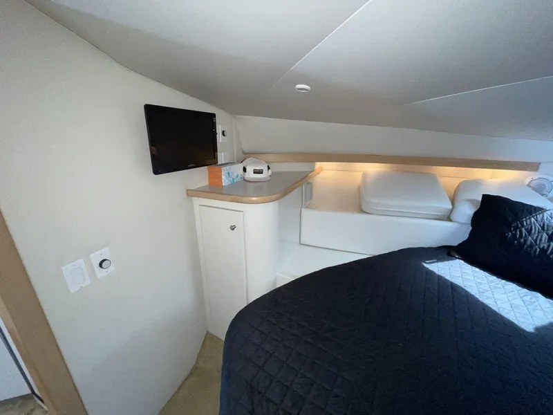 Slide: The Image of 1995 Carver 380 Santego cabin interior with bed, TV, and storage. - 44