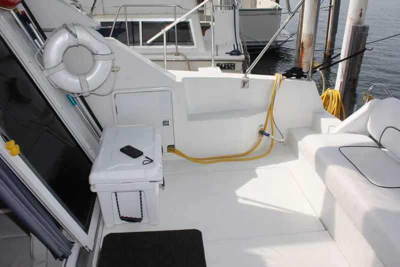 Slide: The Image of 1995 Carver 380 Santego yacht deck with seating, life preserver, and docked at marina. - 7